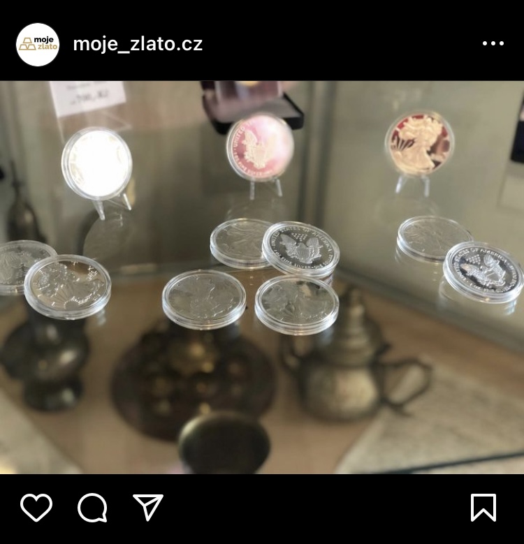 Původní, nejednotný příspěvek Moje-Zlato.cz - rozostřená fotografie mincí ve vitríně